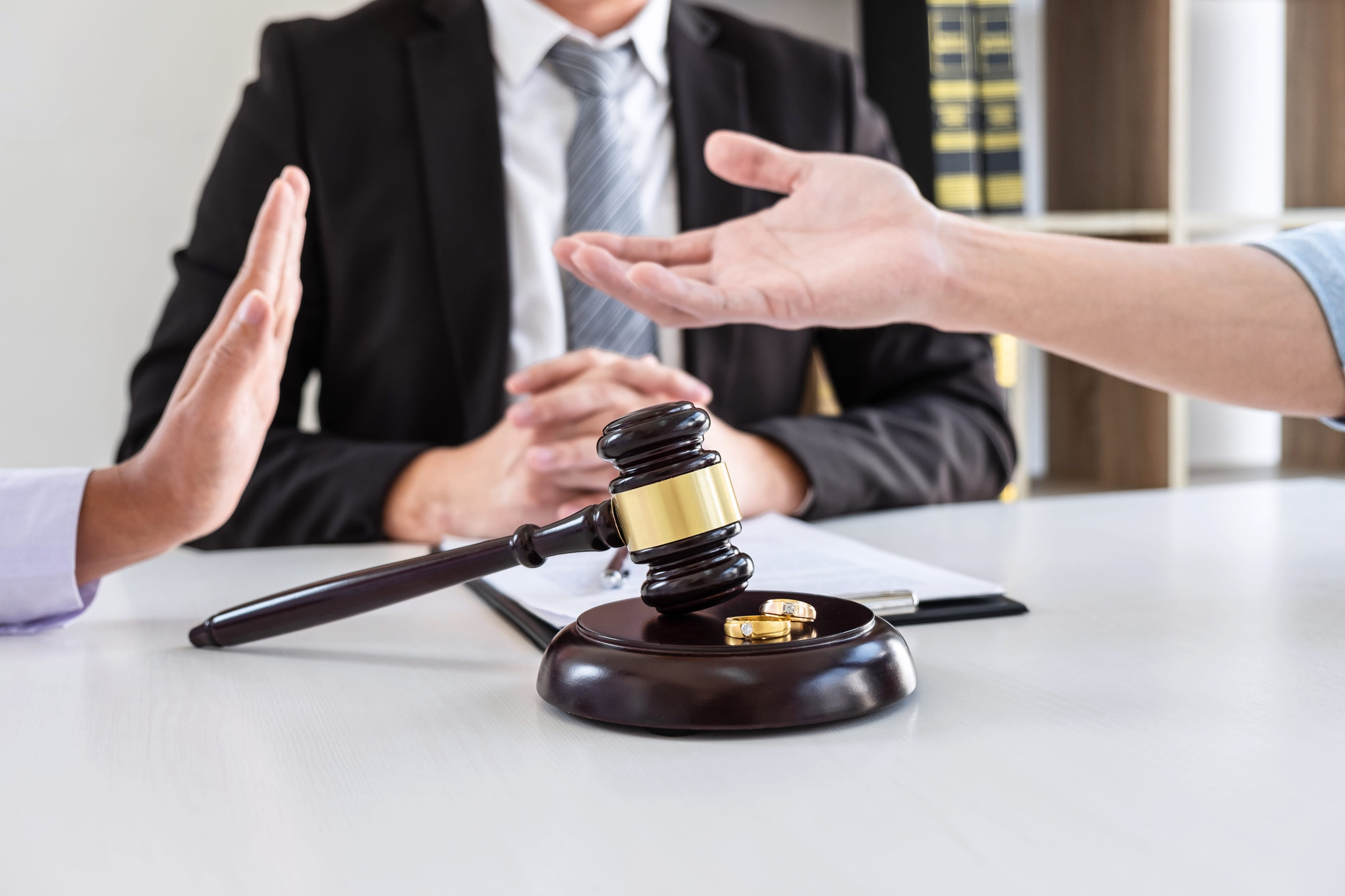 Young angry couple arguing telling their problems in the courthouse to getting divorced or premarital agreement in lawyers office, deciding on marriage divorce concept.